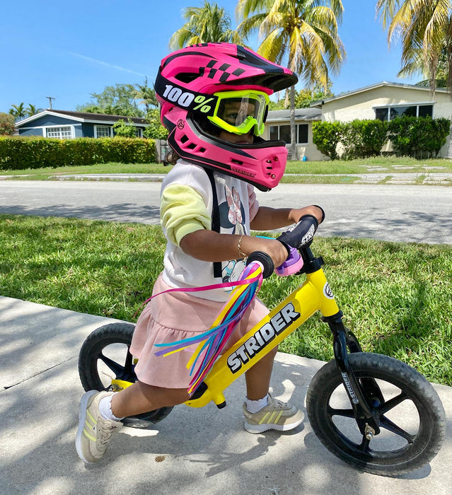 Strider 2-in-1 Full Face Kids Bike Helmet - Child wearing pink helmet